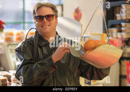 Man with congenital blindness measuring fruit at the grocery store Stock Photo