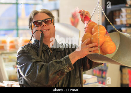 Man with congenital blindness measuring fruit at the grocery store Stock Photo