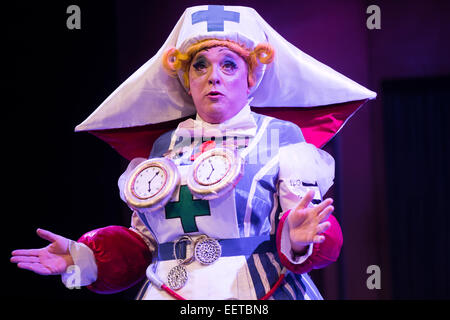 The 'pantomime dame' - male actor in the role of a women - in a group of amateur actors performing in their elaborate costumes on stage in 'Snow White and the Seven Dwarfs' traditional 'panto' pantomime, UK Stock Photo