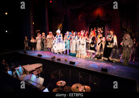 A cast of amateur actors performing in their elaborate costumes on stage for the finale of 'Snow White and the Seven Dwarfs' traditional 'panto' pantomime,  and the band in the orchestra pit playing live music accompaniment UK Stock Photo