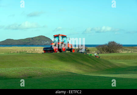 Maintenance work being carried out on a golf course. The tractor is scarifying the  the fairway. Stock Photo