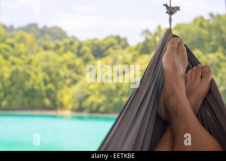 Man's feet on the hammock in the remote Togean Islands, Central Sulawesi, Indonesia. Stock Photo