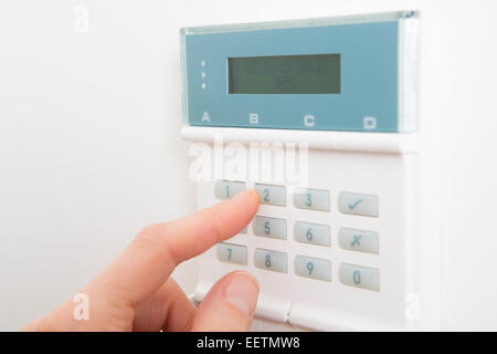 Woman Setting Control Panel On Home Security System Stock Photo