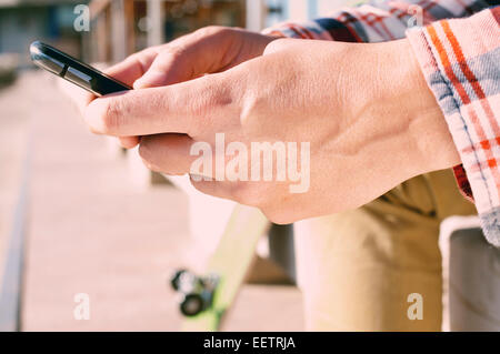 closeup of a young man using a smartphone outdoors Stock Photo