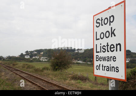 Stop Look Listen Beware of trains sign by railway line. Rural train line. Pedestrian railway crossing. Stock Photo