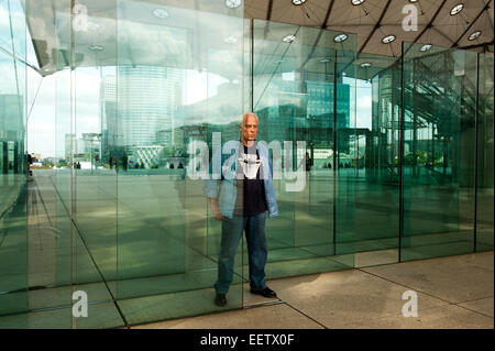Mature male looking through panes of glass Stock Photo