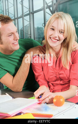 Couple of college students helping each other study Stock Photo