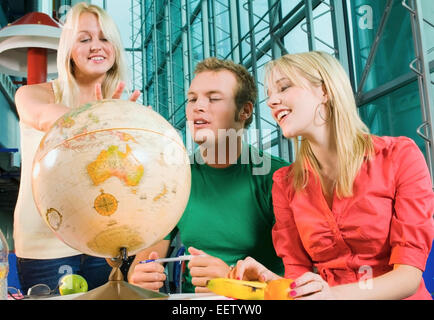 College students in study hall with a desk globe Stock Photo