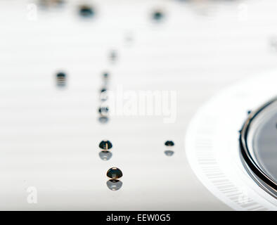These are water droplets that are resting on a compact disc. Stock Photo
