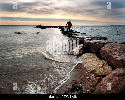 New Haven--a man walks along the jetty at Lighthouse Point Park in New Haven. He enjoying his day off with a walk through the park in the late afternoon.  , Stock Photo