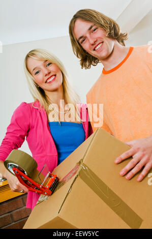 Two people taping up boxes Stock Photo