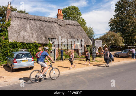 Cyclist passing Thatched Cottage hotel and restaurant, Brockenhurst, Hampshire, England, GB, UK. Stock Photo