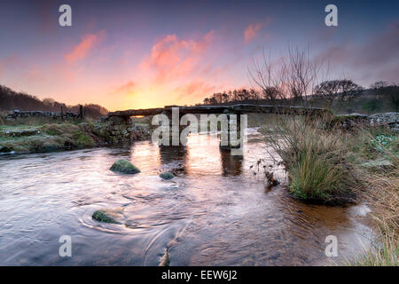 An ancient stone clapper bridge over the East Dart river at Postbridge on Dartmoor in Devon Stock Photo