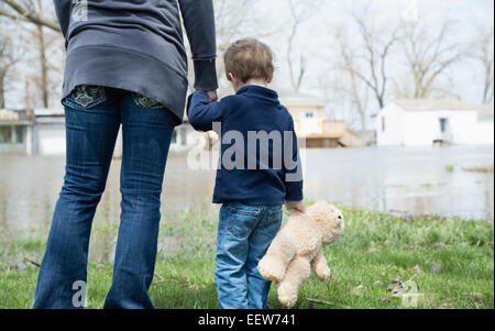 Mother with son standing in flooded town Stock Photo