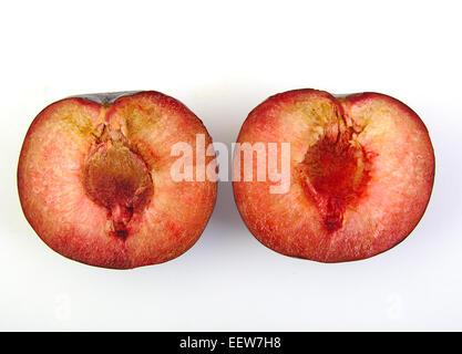 Two plum halves on white background Stock Photo
