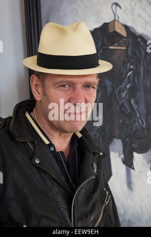 London, UK. 20 January 2015. Pictured: artist Paul Simonon in front of his painting Rocker, 2014. The exhibtition 'Wot no Bike' is a series of new paintings by artist, musician and biker Paul Simonon presented at London's ICA. In these oils on canvas, Simonon, the former bass guitar player with the punk band The Clash, depicts his own personal effects that include biker paraphernalia such as jackets, boots, helmets and gloves alongside packs of cigarettes and books. The exhibition at the ICA runs from 21 January to 6 February 2015. Stock Photo