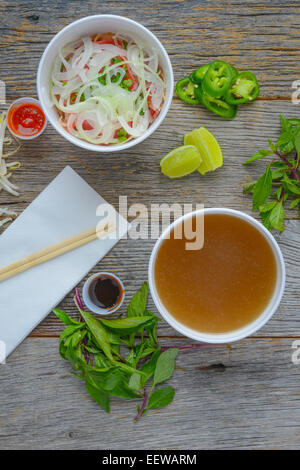 Pho Fast Food To Go on Wood Background with Peppers and Basil Stock Photo