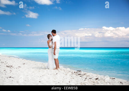Bride and groom looking to each other and holding hands, romantic vacation at Caribbean beach Stock Photo