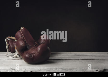 Boxing Gloves lying on two wooden Planks Stock Photo