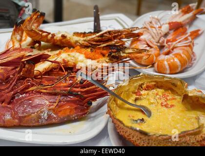 Plates of seafood (clockwise from lower right): spider crab shell, scarlet shrimp, giant tiger shrimp, norwegian lobster Stock Photo