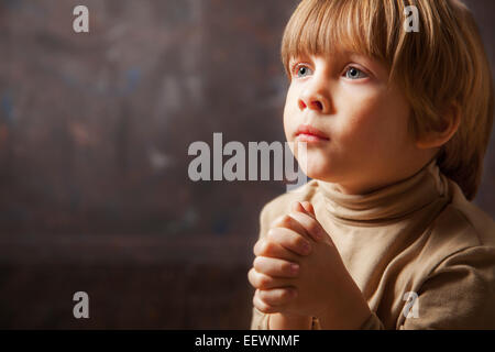Little young beautiful boy spiritual peaceful praying Stock Photo