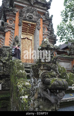 Statue of a dragon guarding the kori agung gate at Pura Taman Saraswati, Ubud, Bali. Stock Photo