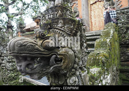 Statue of a dragon guarding the kori agung gate at Pura Taman Saraswati, Ubud, Bali. Stock Photo