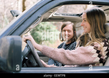 Smiling young couple driving in their car. Stock Photo
