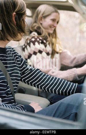 Smiling young couple driving in their car. Stock Photo