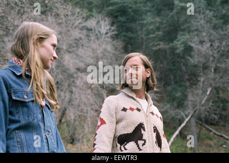 A young couple standing in a forest. Stock Photo