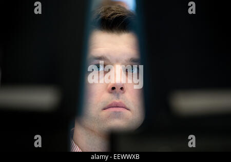 A stockbroker stands on the trading floor and follows the trend of Germany's leading index DAX at the German stock exchange in Frankfurt/Main, Germany, 22 January 2015. PHOTO: Boris Roessler/dpa Stock Photo