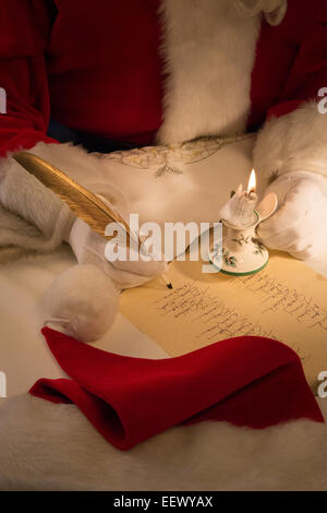 Santa Claus working on Naughty or Nice Gift List, USA Stock Photo