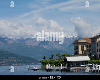 Lakeside view with small jetties and a backdrop of snow capped mountains seen from Bellagio on Lake Como in Italy Stock Photo