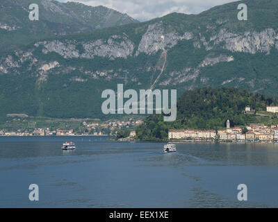 Bellagio from Cadenabbia on Lake Como in Italy with ferries crossing the lake in each direction and a tree lined mountain backdrop Stock Photo
