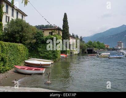 The lakeside village of Pascallo on Lake Como in Italy with small boats in the foreground and a backdrop of mountains