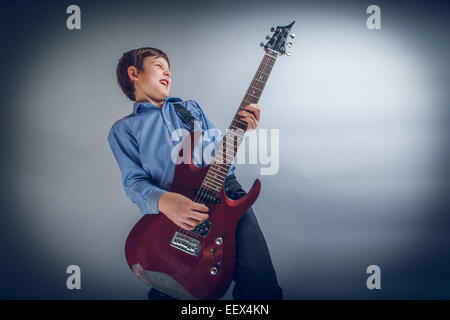 boy teenager European appearance brown emotionally plays guitar Stock Photo