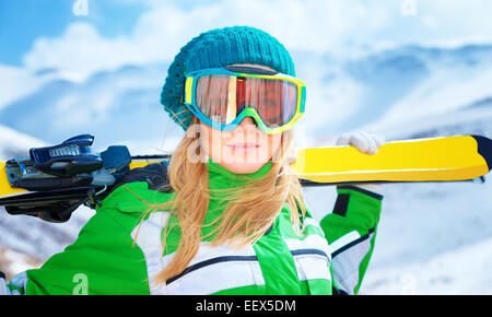 Closeup portrait of cute ski trainer,  active woman wearing sportive goggles and holding in hands ski, active winter vacation Stock Photo