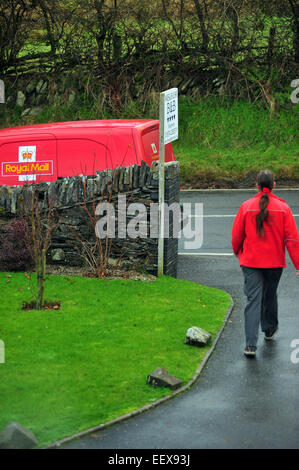 A Royal Mail worker delivering post in a rural part of Wales. Stock Photo