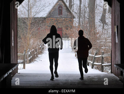 Runners run through the covered bridge at the Eli Whitney Museum during Saturday's snow storm. Stock Photo