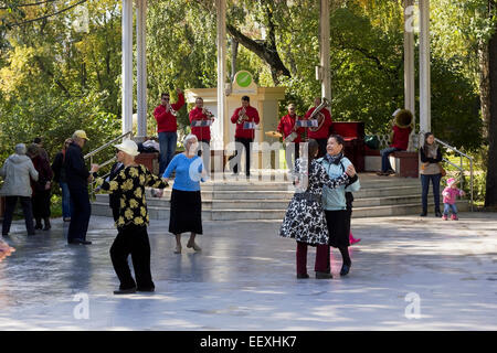 MOSCOW, RUSSIA - SEPTEMBER 20, 2014: Elderly pensioners dance in city park. Plays brass band. Solar autumn Saturday morning. Stock Photo