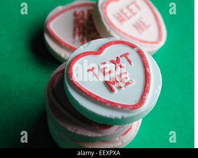 Text  me written on Love Hearts confectionery sweets made by Swizzels Matlow Limited, featuring the iconic pastel heart-shaped candies with romantic messages, a popular British sweet brand widely associated with gifts, Valentine’s Day and nostalgic confectionery culture, United Kingdom. Stock Photo