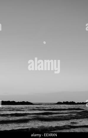 An incredible moon rise over the sea in Italy Stock Photo