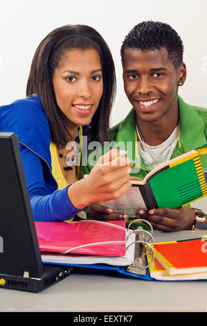 Two students in a classroom with a laptop Stock Photo