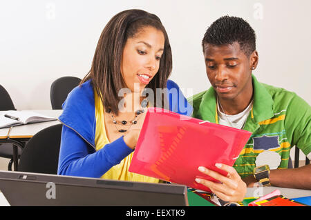 Two students in a classroom with a laptop Stock Photo