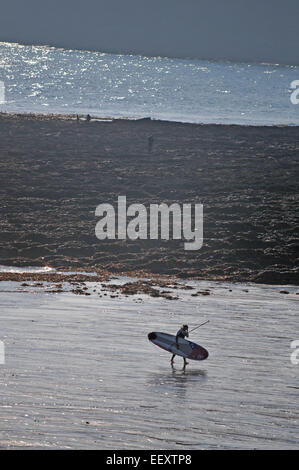 Surfer in the early evening on Gyllyngvase Beach, Falmouth, UK Stock Photo