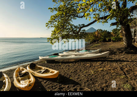 Lakeside scene & canoes at Merida in island's SE corner & Concepcion volcano; Merida, Omotepe Island, Lake Nicaragua, Nicaragua Stock Photo