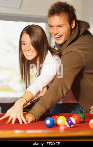 Man showing woman how to play pool Stock Photo