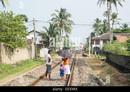 Locals walking along train tracks due to infrequent train services.Hikkaduwa, Sri Lanka.This track was destroyed in tsunami. Stock Photo