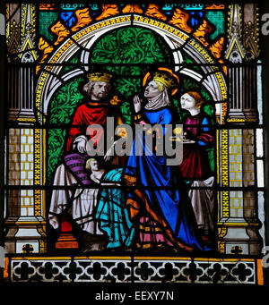 Stained glass window depicting a King and Queen praying for their ill son, in the Cathedral of Rouen, France Stock Photo