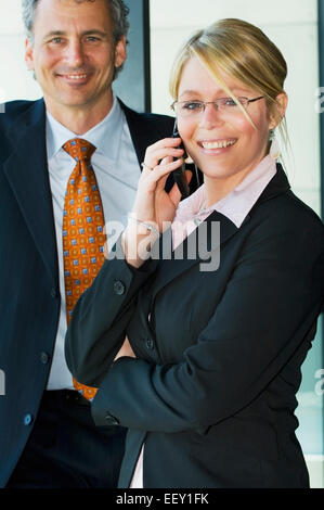 Businesswoman in airport using cellular phone Stock Photo